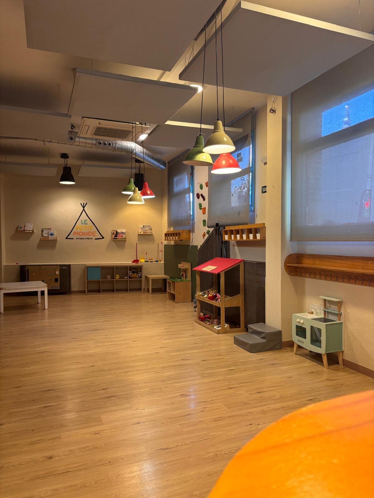 Sala diáfana con suelo de madera y lámparas de colores