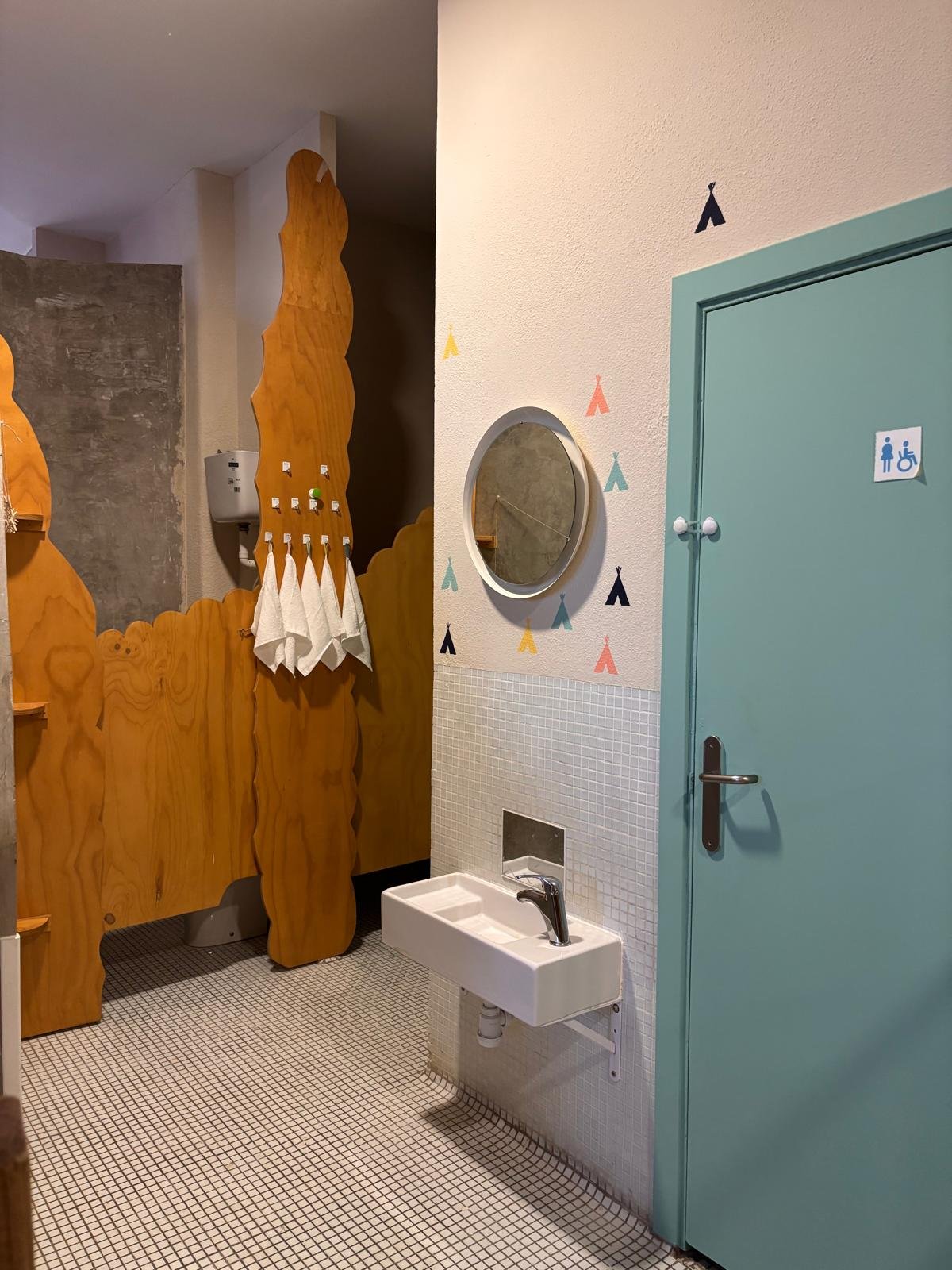 Baño infantil con lavabo bajo y decoración de tipis