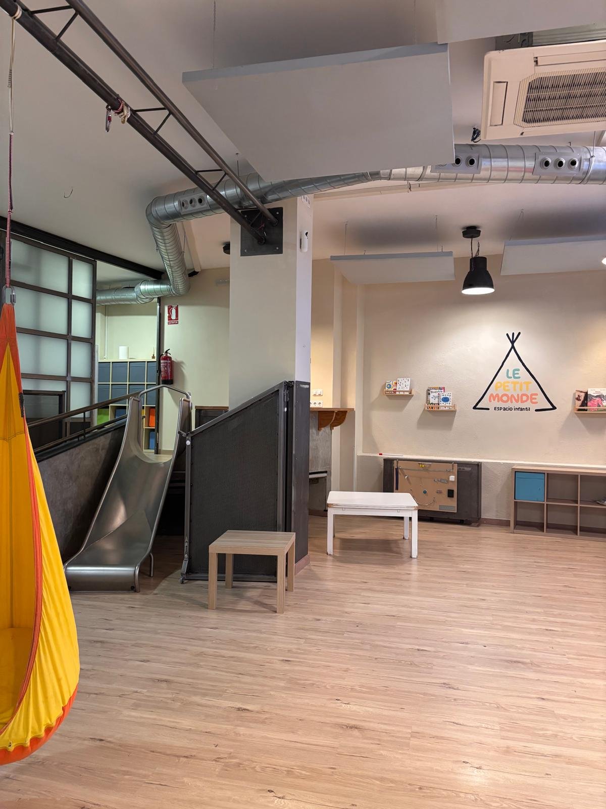 Sala principal con tobogán y el logo de Le Petit Monde al fondo