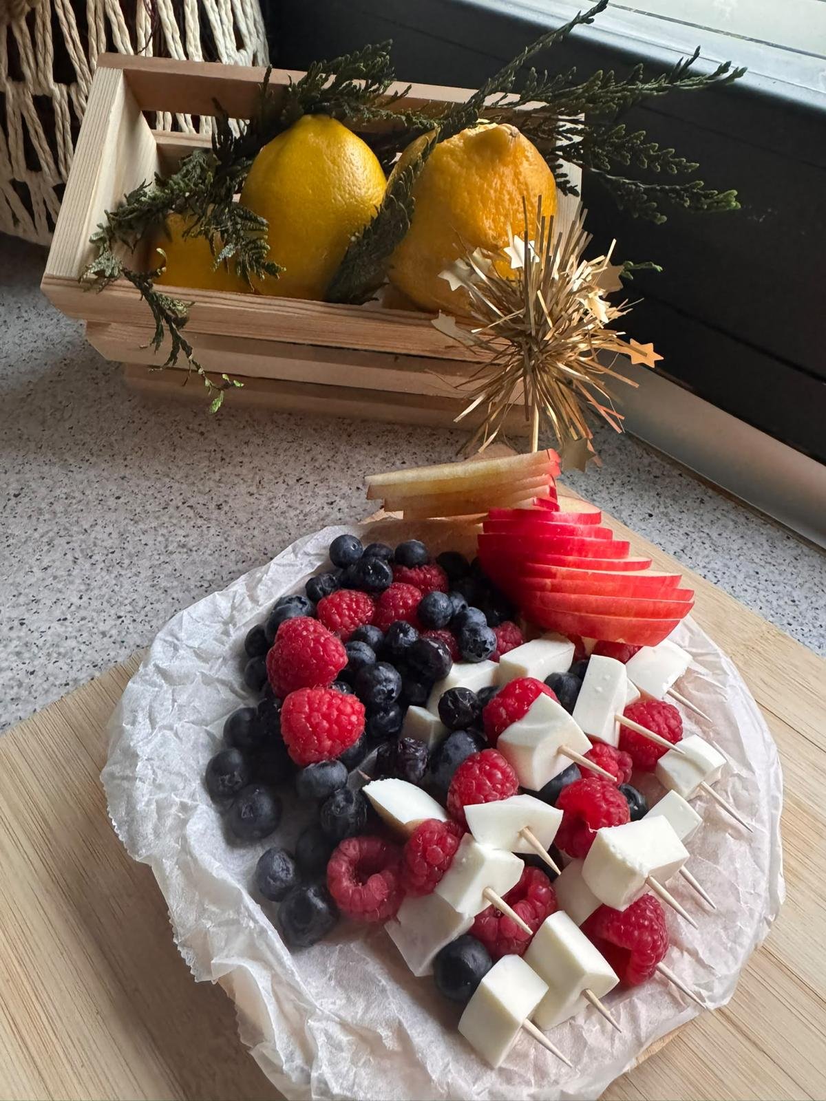 Plato de fruta con brochetas de queso y frambuesas